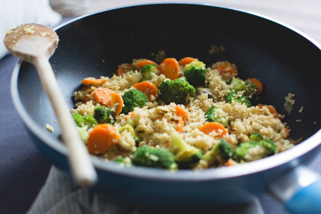 Pan with grains, broccoli and carrots cooking.