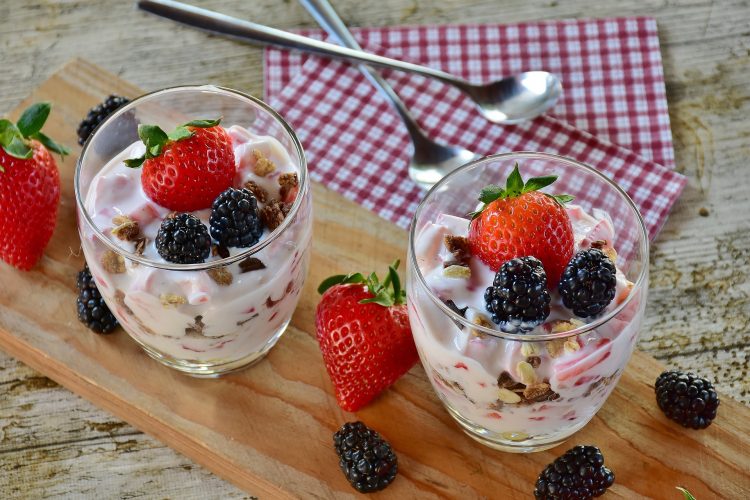Yogurt parfait with plain yogurt, berries, granola and whole fruit.