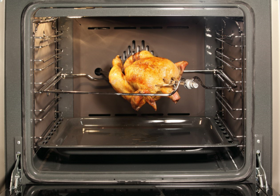 Chicken roasting in oven with thermometer.