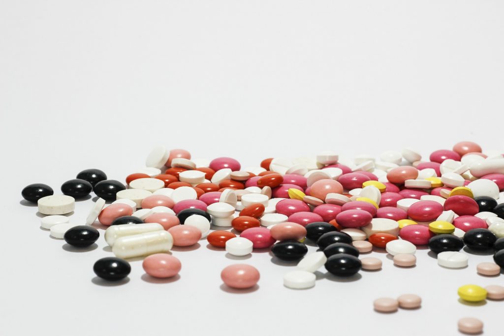 Pile of a variety of pills of different shapes and colors.