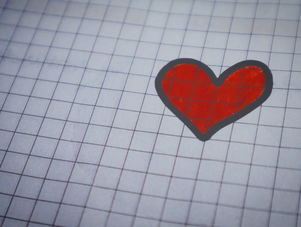 Graph paper with a red and black heart drawn on it.