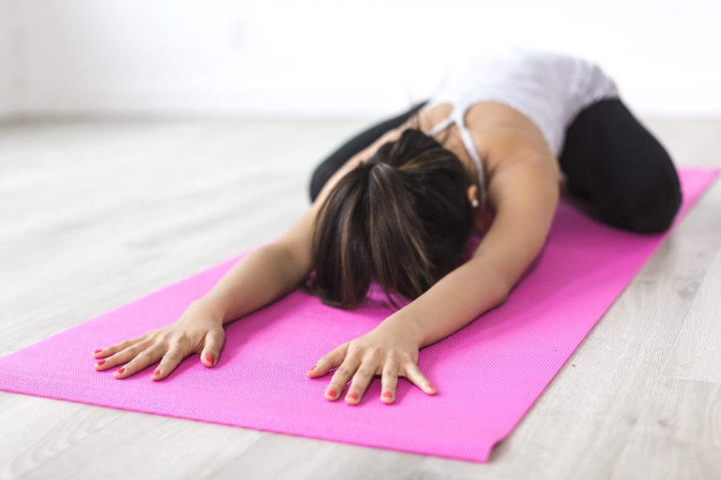 Woman in on yoga mat inchild's pose