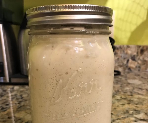 Sourdough starter in jar on countertop.