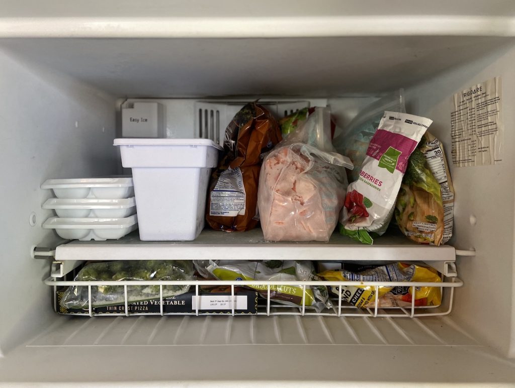 Freezer filled with various foods.
