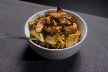 Crispy brussel sprouts in bowl with spoon.