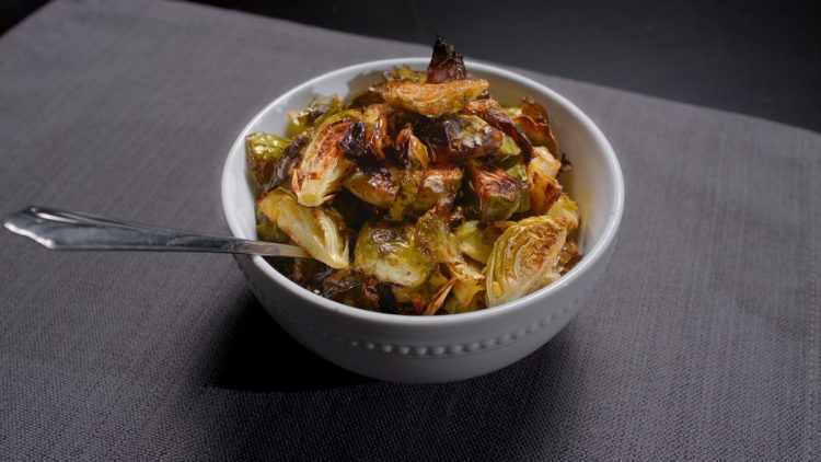 Crispy brussel sprouts in bowl with spoon.