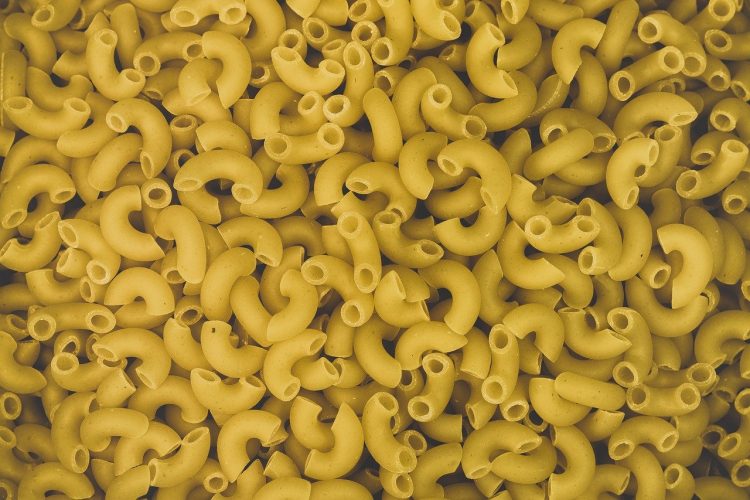 Pile of uncooked macaroni noodles.